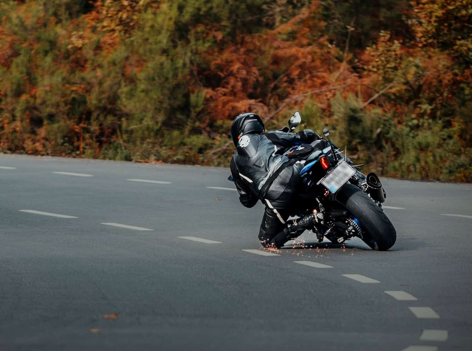 person on motorcycle about to scrape the ground