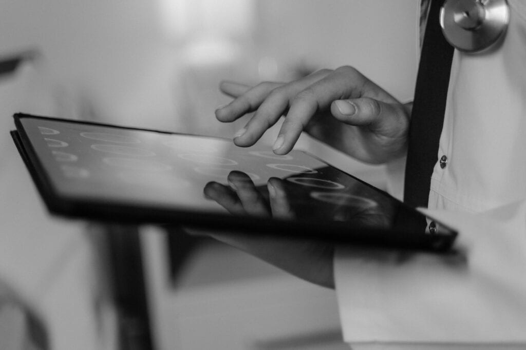 physician looking at labs on a tablet